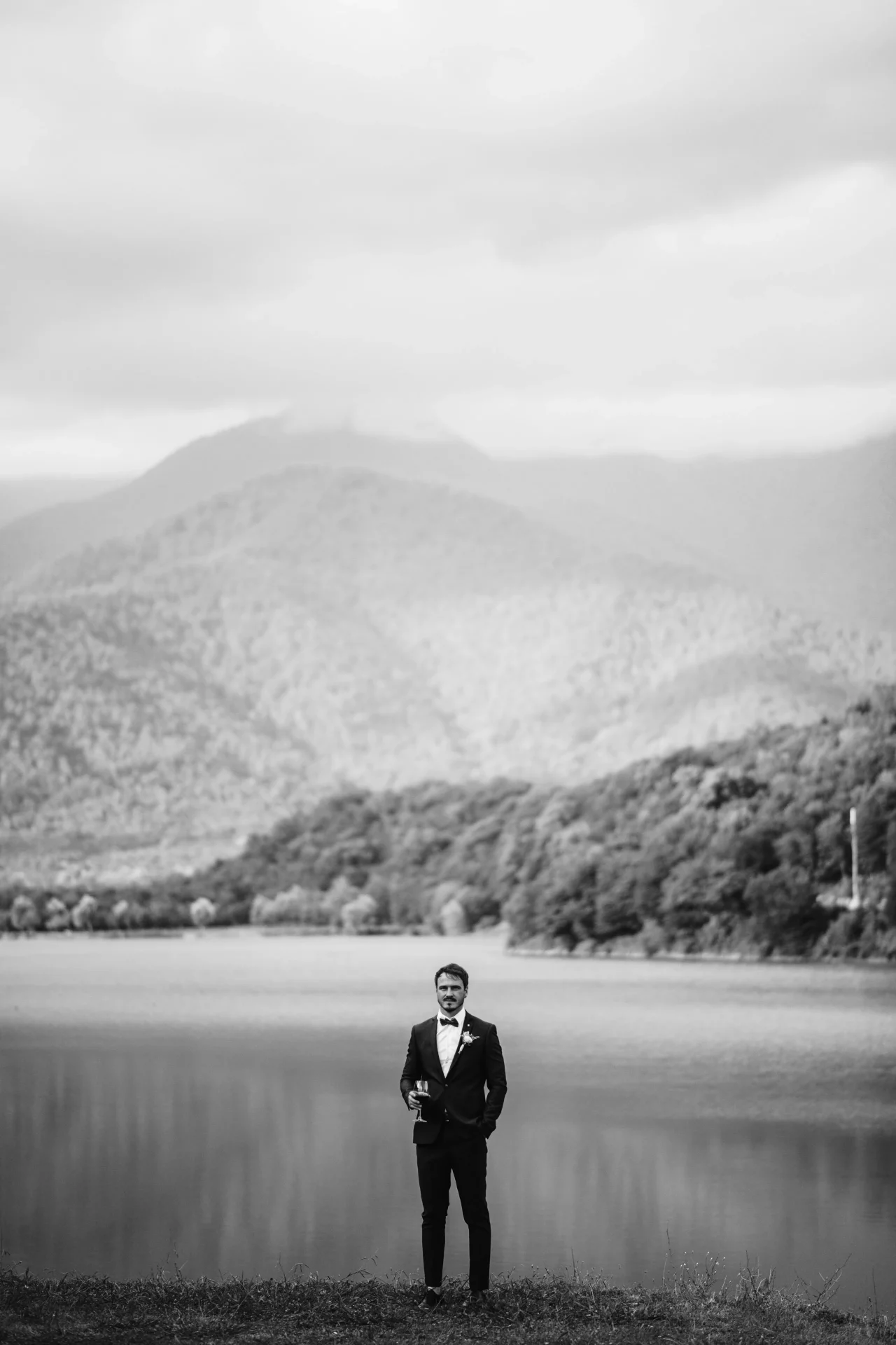 Groom on the background of the lake in Georgia
