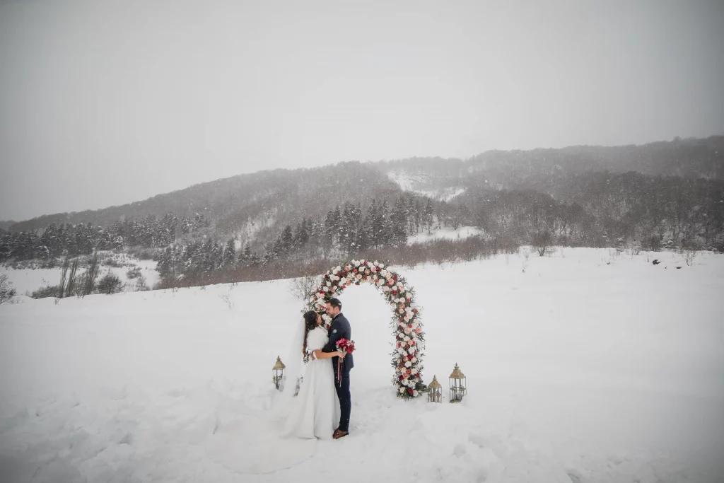 Wedding with an arch in the mountains in winter with snow