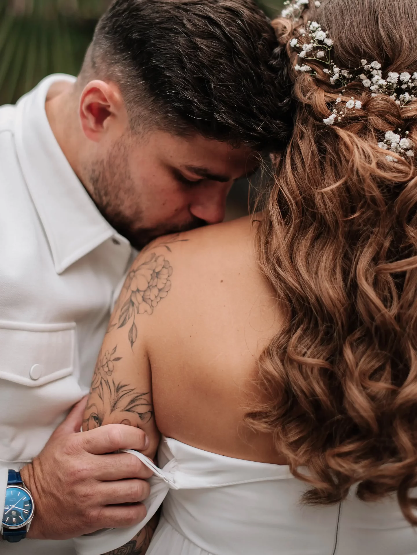 A groom at a wedding in Georgia kisses the bride's shoulder